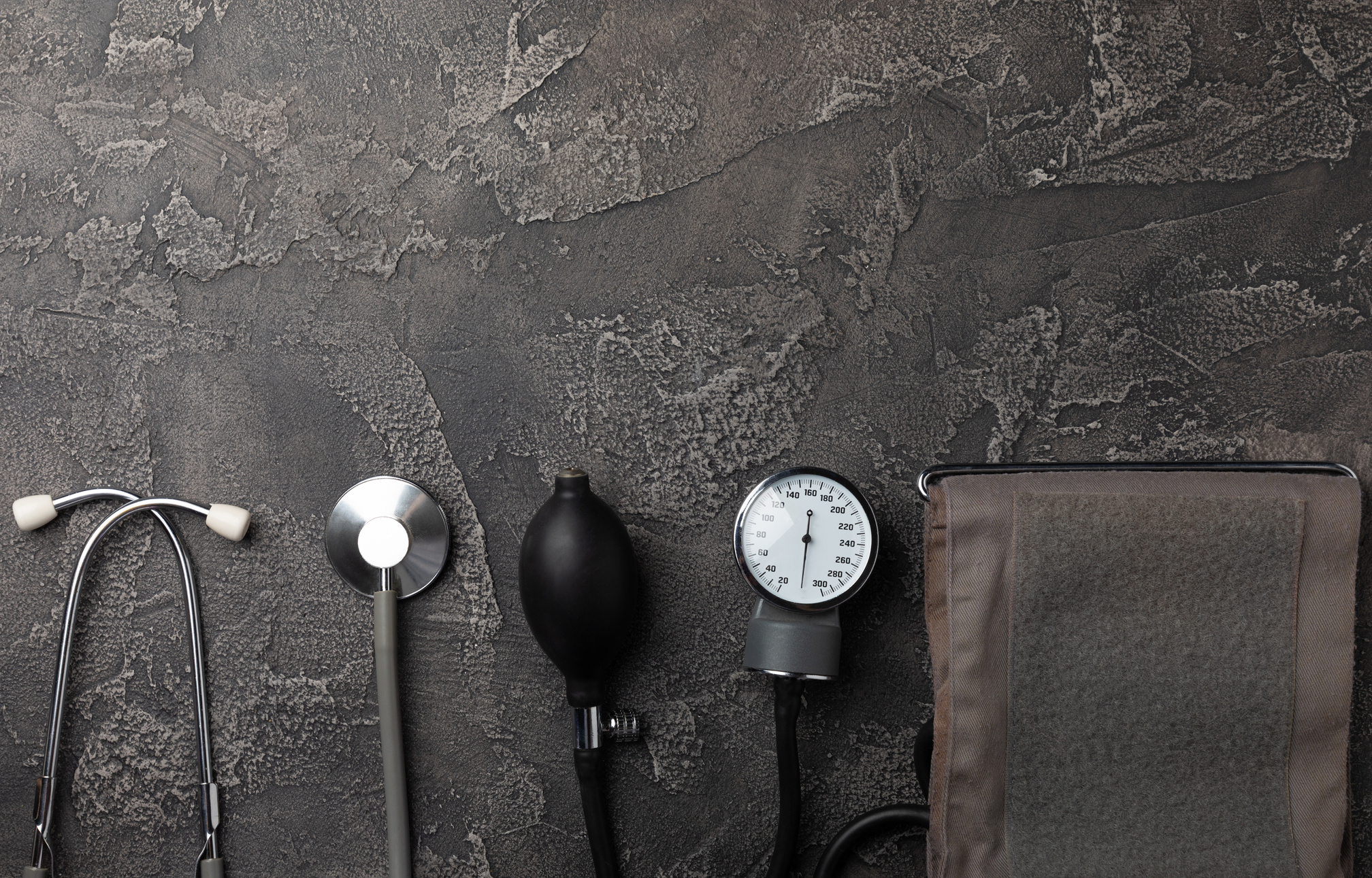 Black blood pressure monitor on a black marble background.Medical equipment blood pressure monitor.Health care. Place for text. Medicine concept. The concept of cardiology.