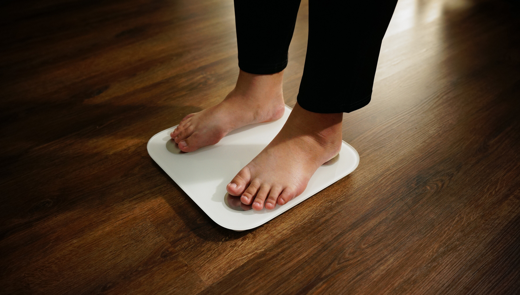 Fat diet and scale feet standing on electronic scales for weight control.
